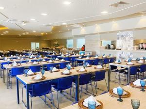 a dining room with tables and blue chairs at Olimpia Park Resort in Olímpia