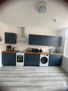 a kitchen with blue cabinets and a washing machine at The Albion Hotel in Hull