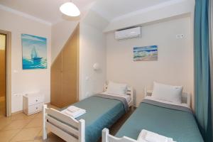 a bedroom with two beds and a sailboat in it at Maisonette Allegro in Ormos Panagias +28 photos