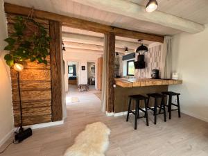 a kitchen with a counter and bar with stools at Casa de Sus - Pe Dealul Mieilor - Cabană în Măguri, Cluj in Măguri