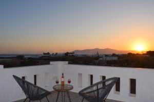 a table and chairs on a balcony with a sunset at Eleonas I in Maragkas