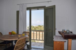 a dining room with a table and a balcony at Eleonas I in Maragkas