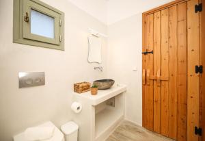 a bathroom with a sink and a wooden door at Eleonas I in Maragkas +42 photos