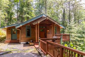 a cabin in the woods with a wooden deck at Peace of Mind at Hound Ears in Valle Crucis