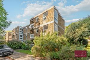 an apartment building with a car parked in front of it at Richmond Three Bedroom Flat in Whitton