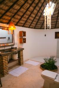 a bathroom with a sink and a mirror and a toilet at Kitejuba Bungalows in Tatajuba