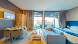 a hotel room with a blue couch and a bed at Atlas-Résidence by Rent-Inn in Rabat
