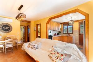 ein Wohnzimmer mit einer weißen Couch und einer Küche in der Unterkunft Villa El Castillejo Vacacional in Vega de San Mateo