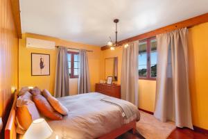 ein Schlafzimmer mit gelben Wänden, einem Bett und einem Fenster in der Unterkunft Villa El Castillejo Vacacional in Vega de San Mateo