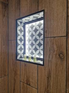 a mirror on a wooden wall with three candles at PASTO GAUCHE Appartement Nice 6P in Nice