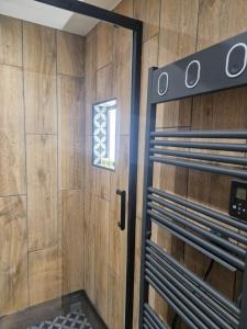 a bathroom with a shower with a wooden wall at PASTO GAUCHE Appartement Nice 6P in Nice