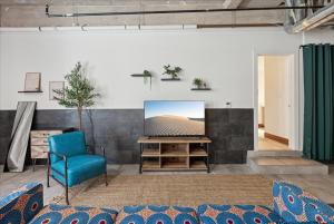 een woonkamer met een tv en een blauwe stoel bij Historic Downtown Condo no 102 in Dallas