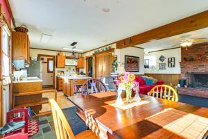 cocina y sala de estar con mesa de madera con flores en Relaxation Meets Upstate Adventure at Salem Home!, en Rupert