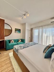 a bedroom with a large bed and a green couch at Mont Oreb Villas Ambre Flic en Flac in Midlands Station