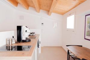 eine Küche mit weißen Wänden und einer Holzdecke in der Unterkunft Cielo D'Alcamo Palazzo Oliva in Alcamo