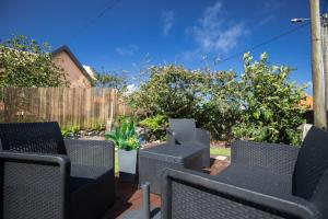 a patio with black chairs and a fence at Casa Serafina by Rent-a-key in Santa Maria Madalena