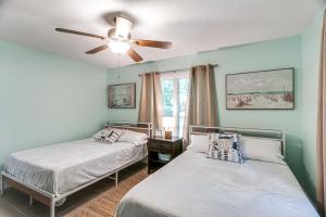 a bedroom with two beds and a ceiling fan at 4 Mi to St Simons Beach Modern Getaway with Sunroom in Blackbanks