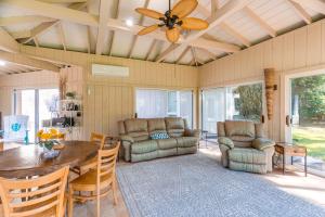 a living room with a ceiling fan and a table and chairs at 4 Mi to St Simons Beach Modern Getaway with Sunroom in Blackbanks