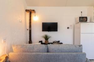 a living room with a couch and a tv on a wall at Casa Serafina by Rent-a-key in Santa Maria Madalena