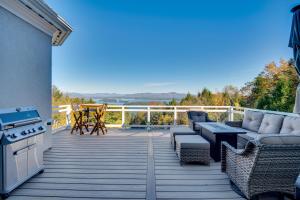 a deck with a stove and a couch and a grill at Million-Dollar Mtn Views! Gilford Gilded Loon in Glendale