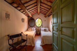 an attic room with two beds and a window at Villa Adele - Historic Dimora with pool & sea view in Senigallia