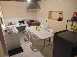 a kitchen with a table and a white table and a refrigerator at Small House Pisac in Pisac