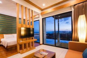 a room with a bed and a tv and large windows at Sea & Mountain View Private Pool Villa at Aonang Beach in Krabi town