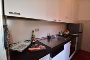 a kitchen with a sink and a counter with wine bottles at Timeless Garden Lake Como in Gravedona