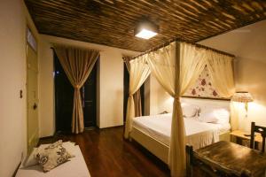 a bedroom with a canopy bed and a window at Pousada Portas da Amazônia in São Luís