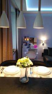 a table with plates and a vase with flowers on it at A3XD Apartament in Częstochowa