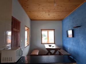 a kitchen with a table and a microwave in a room at hospedagem- Bela Vista in Milho Verde
