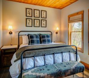a bedroom with a bed with blue pillows and a window at Owls Nest in Seven Devils
