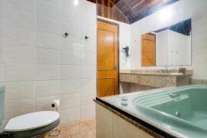 モンテ・ヴェルデにあるPousada das Pedrasの浴槽、トイレ、洗面台を備えたバスルーム