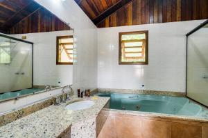 モンテ・ヴェルデにあるPousada das Pedrasの浴槽と洗面台のあるバスルーム