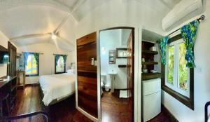 a bedroom with a bed and a mirror at Colinda Cabanas in Caye Caulker