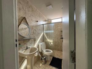 a bathroom with a sink and a toilet and a mirror at Conforto e espaço garantido no Bessa in Nossa Senhora do Livramento