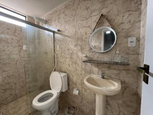 a bathroom with a toilet and a sink and a mirror at Conforto e espaço garantido no Bessa in Nossa Senhora do Livramento