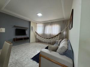 a living room with a couch and a television at Conforto e espaço garantido no Bessa in Nossa Senhora do Livramento +4 photos