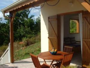 a wooden table and chairs on a patio at GITES MARLYSE in Bouillante