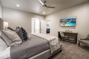 a bedroom with a bed and a desk and a chair at Zion Village Poolhouse in Hurricane with Pool and Hot Tub in Hurricane