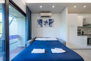 a bedroom with a blue bed with towels on it at Desenzano - 2' to Station & Lake - Pool, Wifi, AC in Desenzano del Garda +22 photos