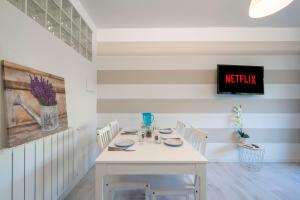 a white dining room with a white table and chairs at Desenzano - 2' to Station & Lake - Pool, Wifi, AC in Desenzano del Garda