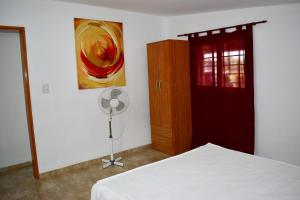 サンタ・ロサ・デ・カラムチタにあるSierras Del Molleのベッドと壁に絵が飾られた寝室