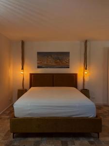 uma cama num quarto com duas luzes acesas em Dimidia - casa vacanze mare montagna em Capaci mais 5 fotografias