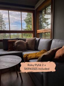 a living room with a couch with pillows and a table at Rinneköngäs - Ruka-Pyhä 2x SKIPASS included in Ruka