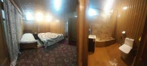 a small room with a bed and a bathroom at House boat MASHAL in Srinagar