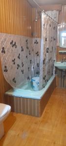 a bathroom with a shower with a curtain with monkeys on it at House boat MASHAL in Srinagar