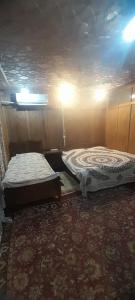 two beds are sitting in a room with at House boat MASHAL in Srinagar