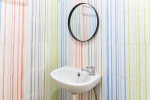 a bathroom with a sink and a mirror on the wall at Behomy Harita Lampung in Geruntang
