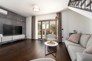 een woonkamer met een bank en een tv bij Villa Casa Minerva in Majkusi